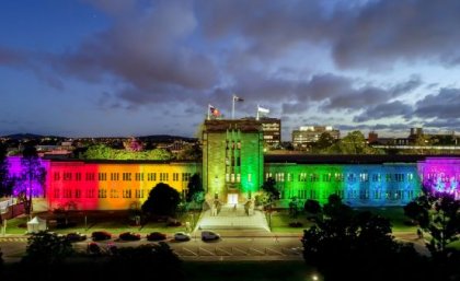 UQ's Forgan Smith Building lit up in rainbow colours. 